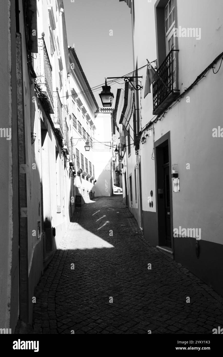 Le strette strade acciottolate e gli edifici sono stati costruiti vicino per respingere il caldo sole nelle storiche città portoghesi. Foto Stock