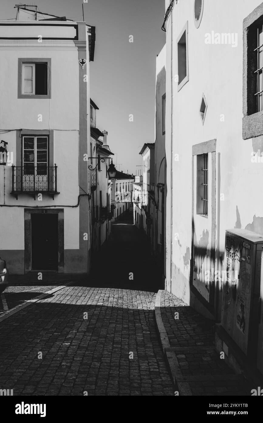 Le strette strade acciottolate e gli edifici sono stati costruiti vicino per respingere il caldo sole nelle storiche città portoghesi. Foto Stock