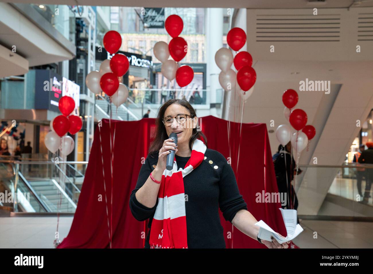 Julie Nelson, membro del Comitato, Light the World Giving Machines, partecipa alla presentazione della Light the World Giving Machine all'Eaton Centre di Toronto. Le macchine per dare luce al mondo sono distributori automatici interattivi che consentono alle persone di fare donazioni di beneficenza "acquistando" articoli come pasti, forniture scolastiche o cure mediche per coloro che ne hanno bisogno. Gestiti dalla Chiesa di Gesù Cristo dei Santi degli ultimi giorni, sono allestiti durante le festività in luoghi selezionati in tutto il mondo per ispirare atti di gentilezza e generosità. Foto Stock