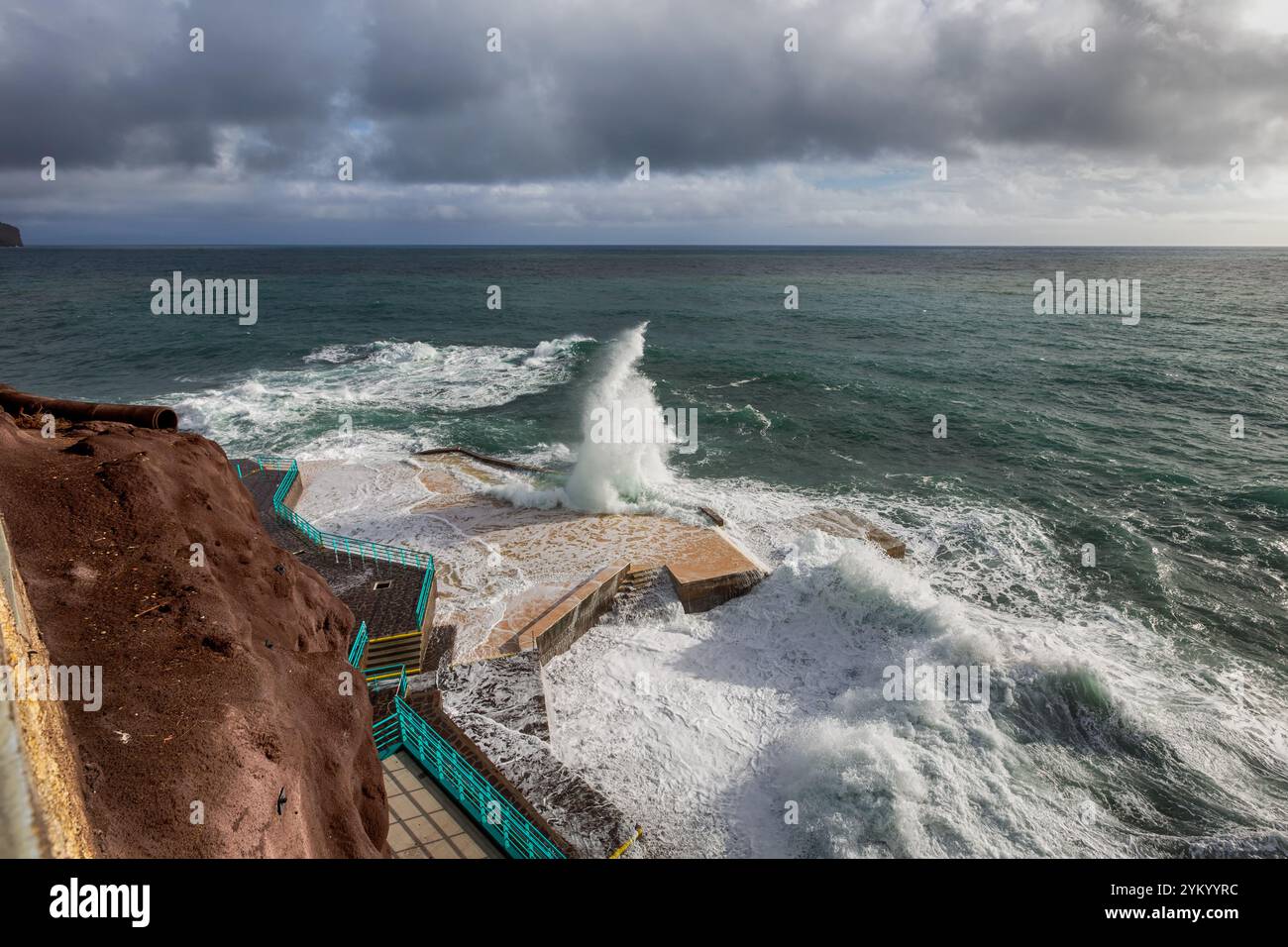 Una splendida vista delle onde che si infrangono drammaticamente contro le strutture costiere di Funchal, Madeira, che mostrano la bellezza selvaggia dell'Oceano Atlantico Foto Stock