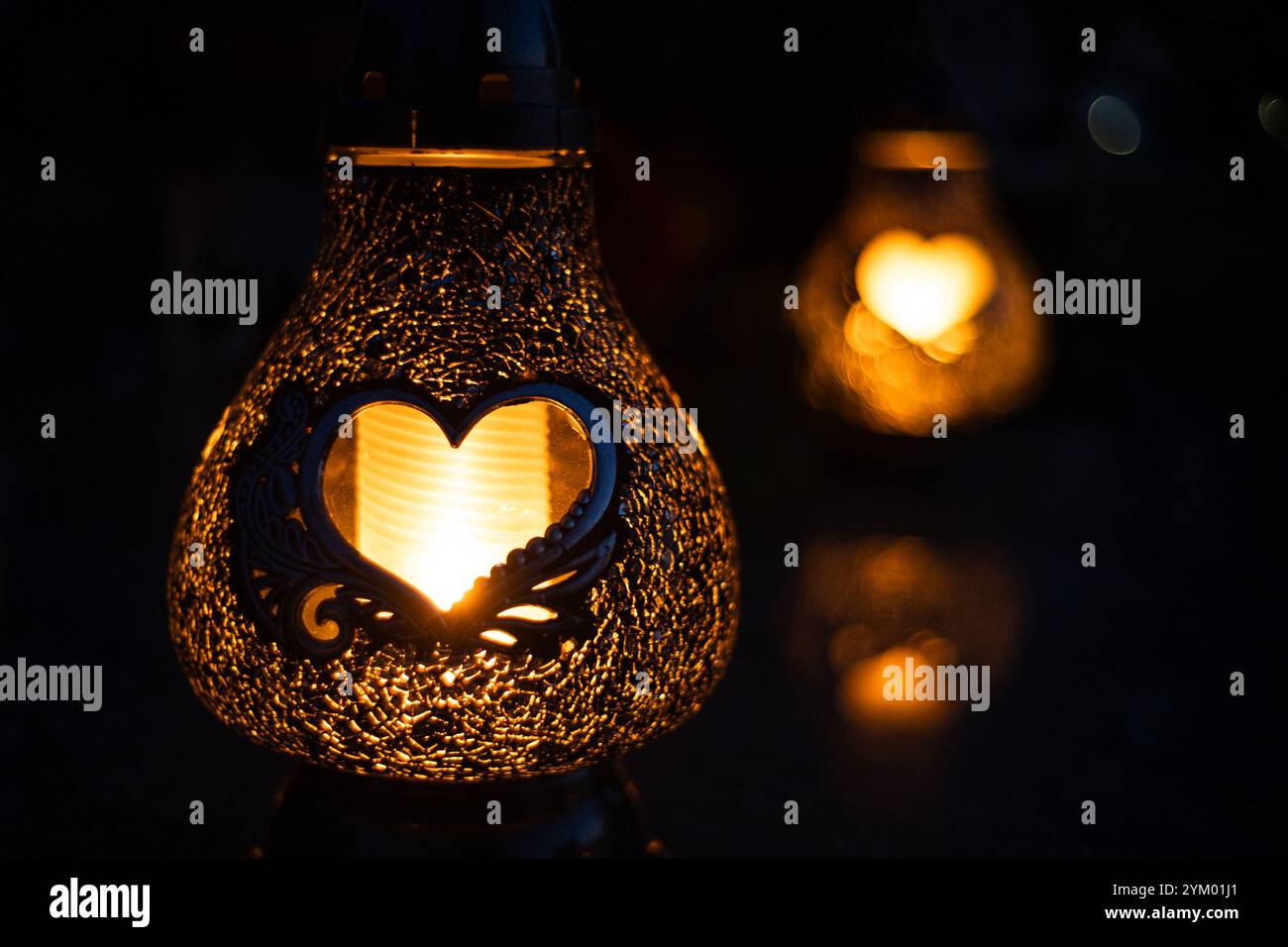 Candele a forma di cuore accese su una tomba il giorno di Ognissanti Foto Stock