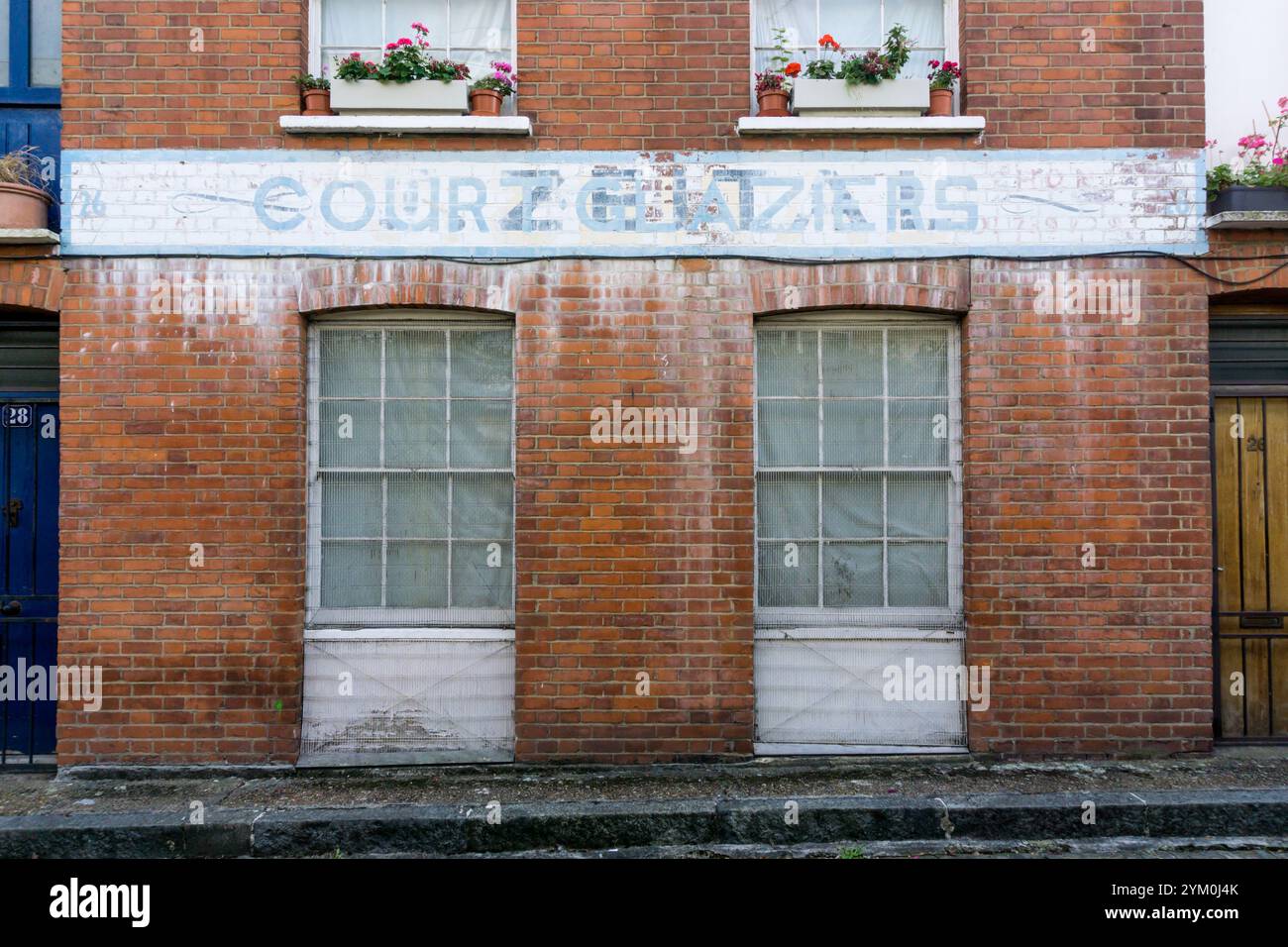Insegna fantasma a Padbury Court, Bethnal Green. Un cartello per i vetri di Corte è stato dipinto su quello per Jacob Zeital, un produttore di armadietti chiuso negli anni '1970 Foto Stock