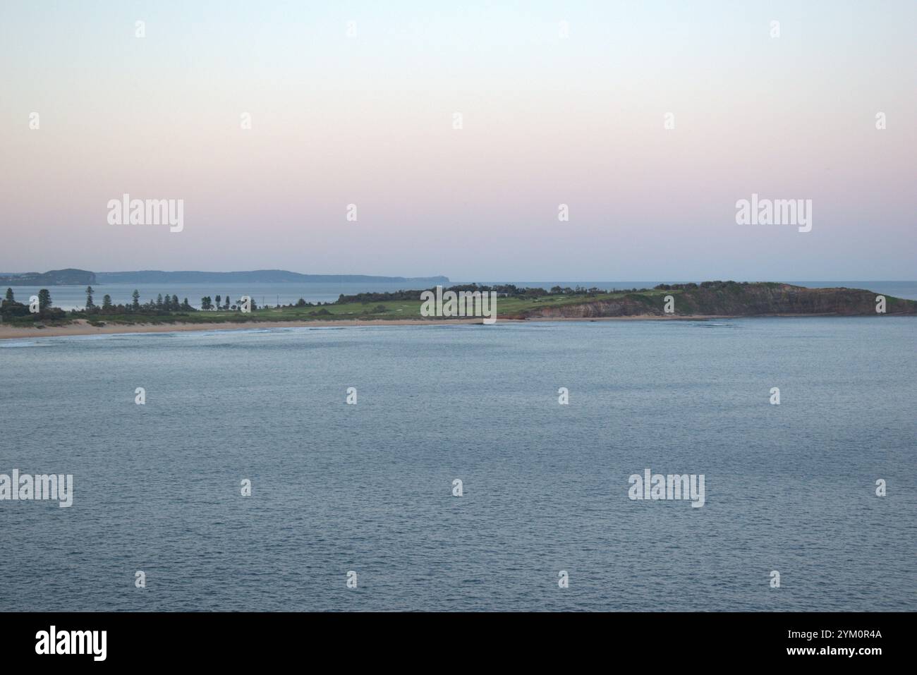 Long Reef Headland visto da Dee Why Headland in una prima serata estiva con un cielo nebbioso Foto Stock