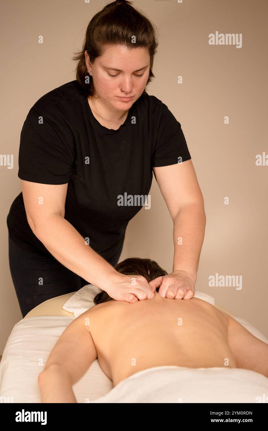Terapista massaggiante i muscoli della spalla con entrambe le mani durante una sessione di terapia. Concetto di benessere e sollievo dallo stress. Foto di alta qualità Foto Stock Terapista massaggiante i muscoli della spalla con entrambe le mani durante una sessione di terapia. Concetto di benessere e sollievo dallo stress. Foto di alta qualità Foto Stock