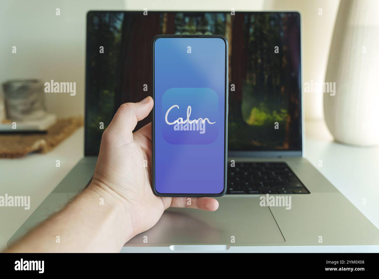 Logo dell'applicazione Calm Meditation sullo schermo dello smartphone di fronte al laptop. Kaunas Lituania - 2024 ottobre 31. Foto di alta qualità Foto Stock