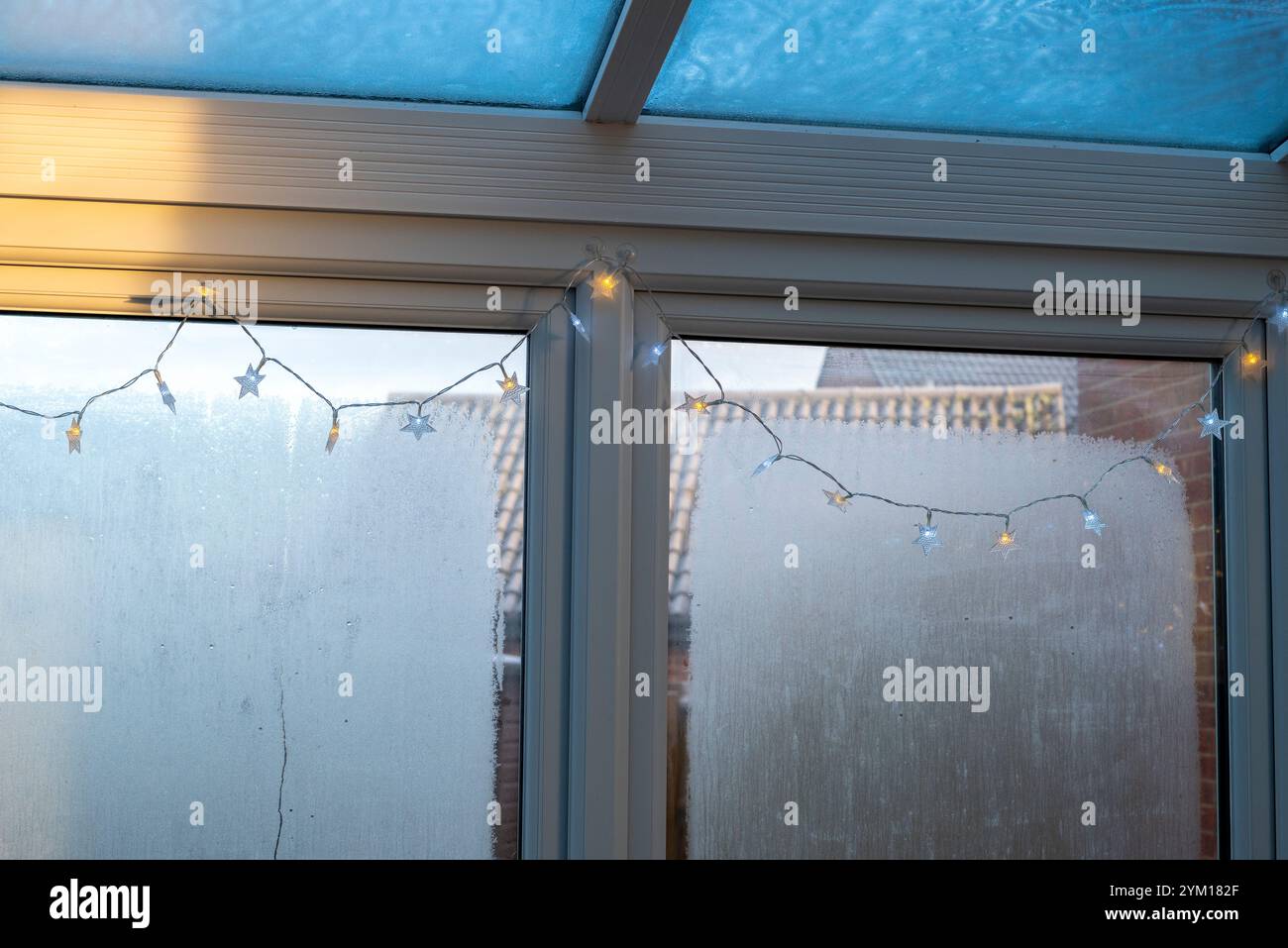 All'interno di una veranda in una mattina fredda e ghiacciata d'inverno con condensa e ghiaccio sulle finestre e sul tetto in vetro. Foto Stock