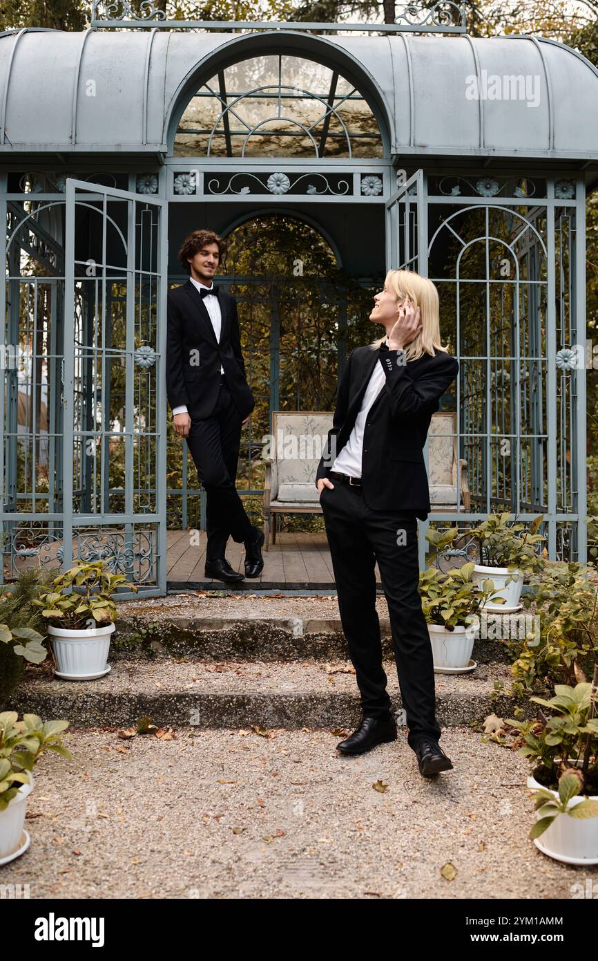 In un incantevole giardino, due giovani vestiti impeccabilmente con un abbigliamento formale condividono un momento di gioco. Foto Stock