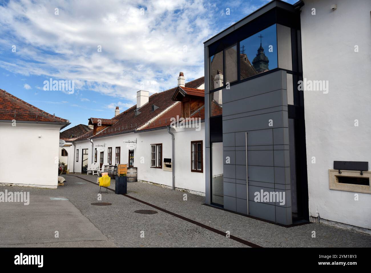 Rust, Austria - 23 marzo 2024: Una fila tradizionale di case combinate con l'architettura moderna con vari negozi di souvenir nelle strette strade della U Foto Stock