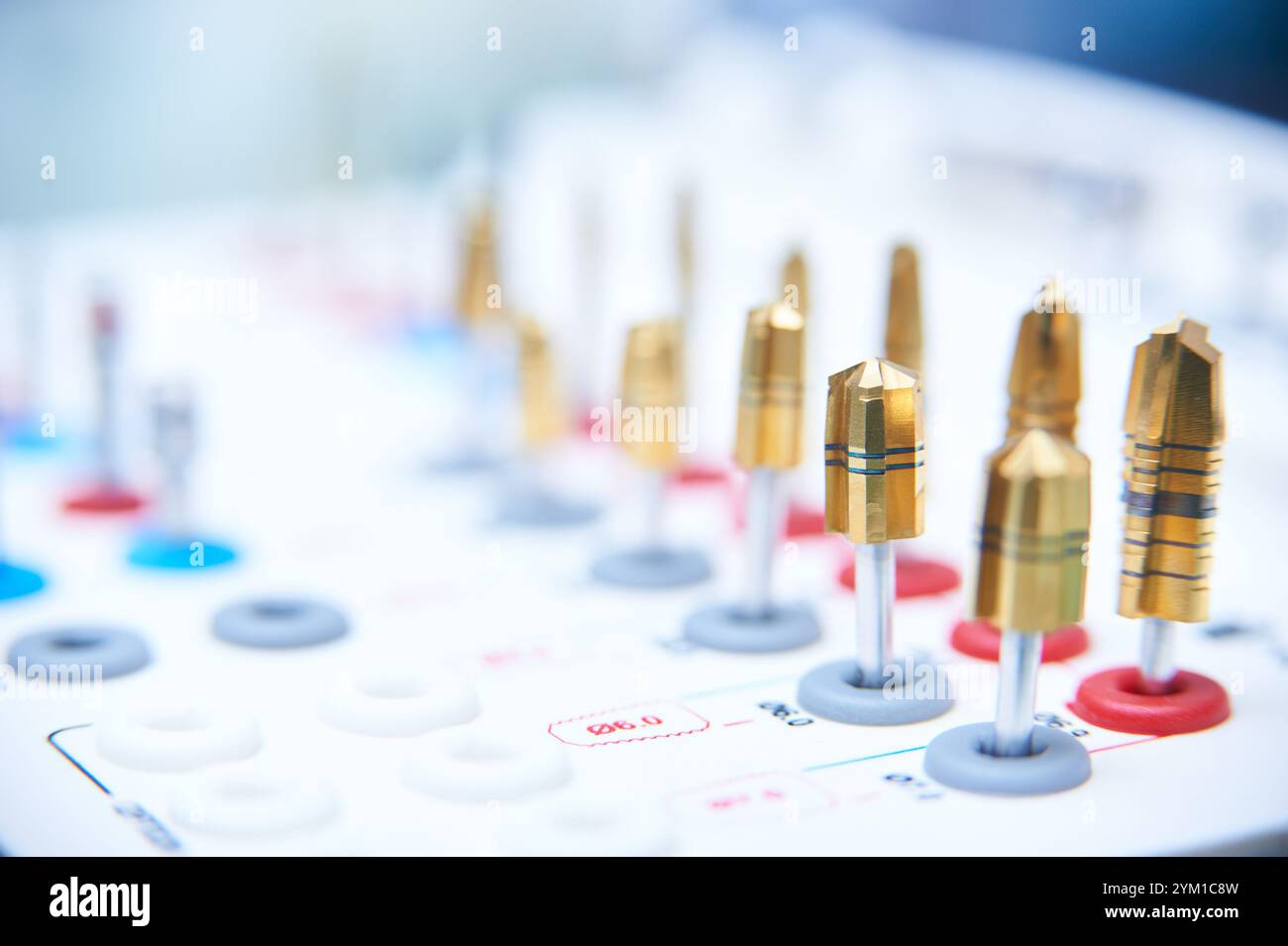 Strumenti di chirurgia dell'impianto dentale su una superficie bianca. Primo piano di punte da trapano d'oro e strumenti di precisione in un ambiente medico o odontoiatrico. Foto Stock