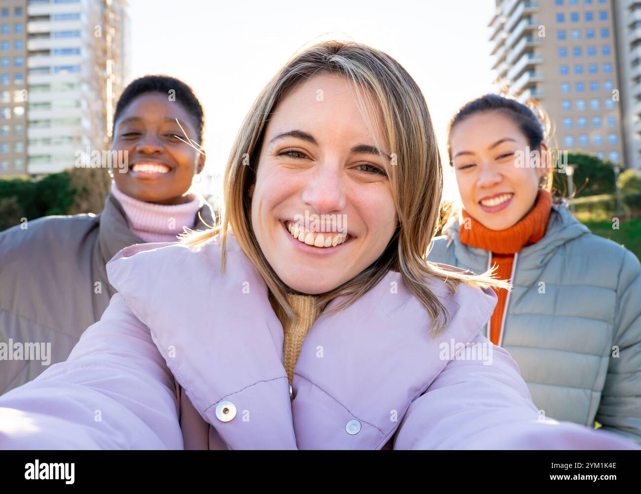 Tre ragazze che scattano un ritratto selfie guardano bene la fotocamera. Foto Stock
