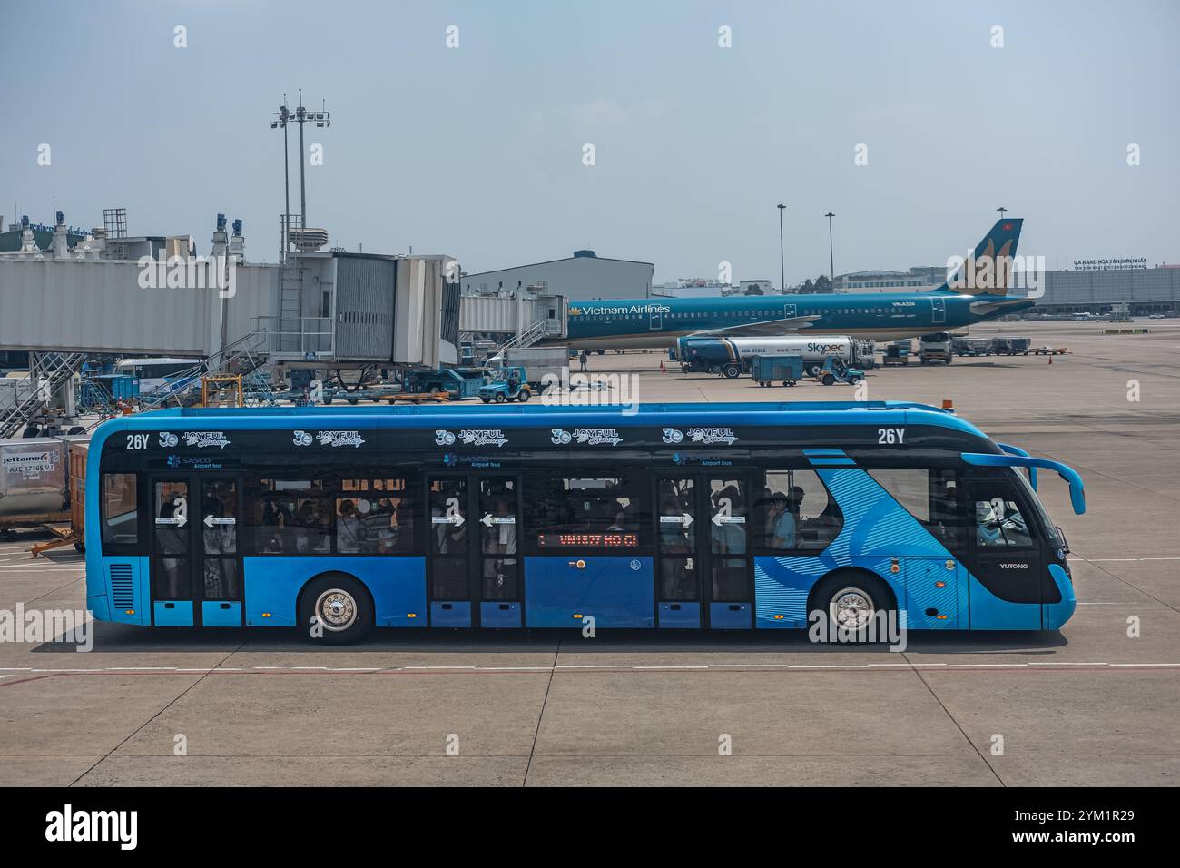 Autobus dell'aeroporto che porta i passeggeri al loro aereo per il volo. Autobus aeroportuale che porta i passeggeri dal terminal all'aereo, noi Bai Internati Foto Stock