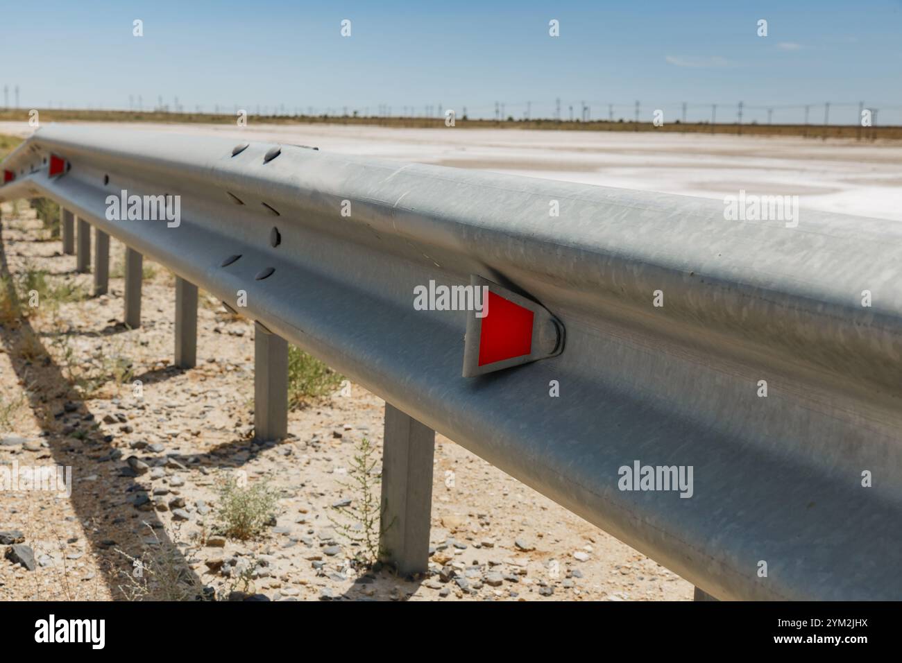 catarifrangenti stradali rossi lungo la strada. recinzione stradale metallica. Sicurezza stradale e stradale Foto Stock