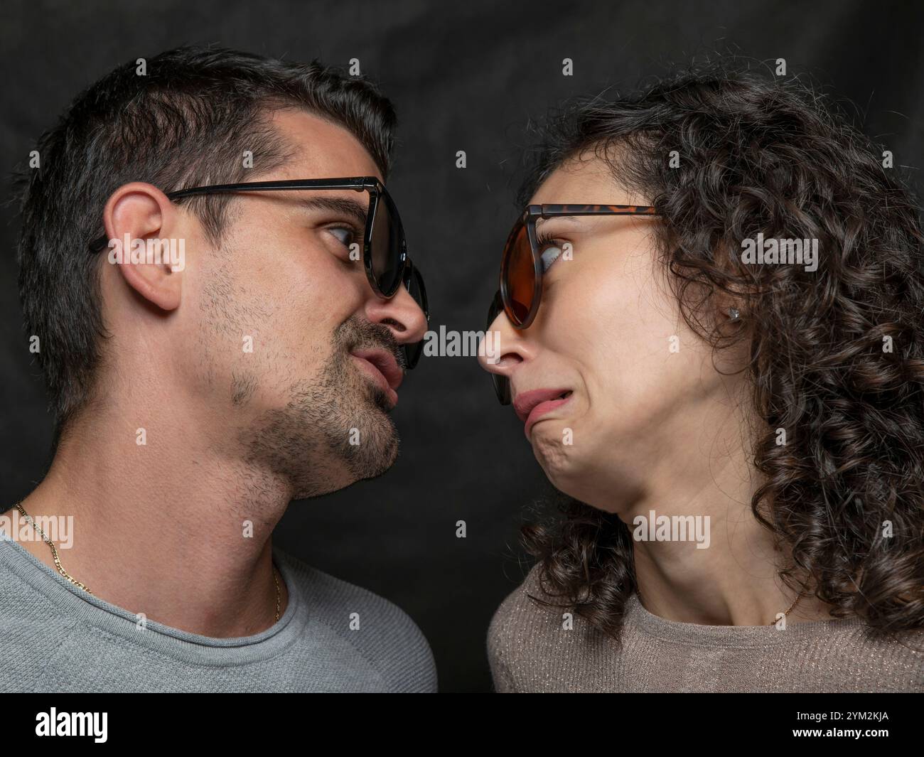 Un uomo e una donna si guardano da vicino, facendo facce divertenti e divertenti Foto Stock