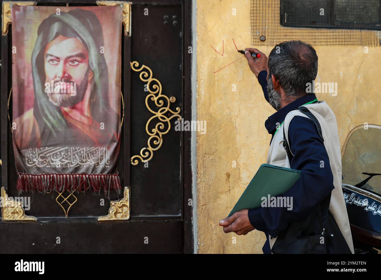 Baghdad, Iraq. 20 novembre 2024. Un ufficiale del censimento sul campo segna una casa durante il primo giorno del censimento nazionale iracheno nella città di Sadr a Baghdad. L'Iraq sta conducendo il suo primo censimento nazionale della popolazione in 37 anni, una mossa che dovrebbe avere un impatto sulla distribuzione delle risorse, che ha riacceso le tensioni tra Baghdad e la regione semi-autonoma del Kurdistan con il timore che un declino della popolazione curda possa ridurre la loro influenza politica e i loro diritti economici. Crediti: Ameer al-Mohammedawi/dpa/Alamy Live News Foto Stock