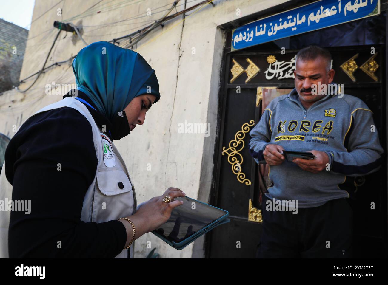 Baghdad, Iraq. 20 novembre 2024. Un ufficiale del censimento sul campo raccoglie dati da un residente durante il primo giorno del censimento nazionale iracheno nella città di Sadr a Baghdad. L'Iraq sta conducendo il suo primo censimento nazionale della popolazione in 37 anni, una mossa che dovrebbe avere un impatto sulla distribuzione delle risorse, che ha riacceso le tensioni tra Baghdad e la regione semi-autonoma del Kurdistan con il timore che un declino della popolazione curda possa ridurre la loro influenza politica e i loro diritti economici. Crediti: Ameer al-Mohammedawi/dpa/Alamy Live News Foto Stock