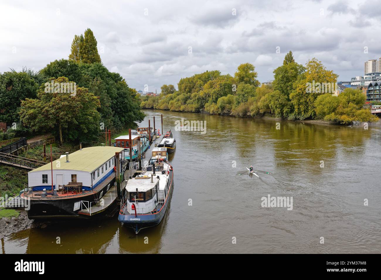 Il fiume Tamigi visto dal ponte di Kew che guarda verso il fiume Brentford con case galleggianti ormeggiate e appartamenti moderni Greater London Inghilterra Regno Unito Foto Stock