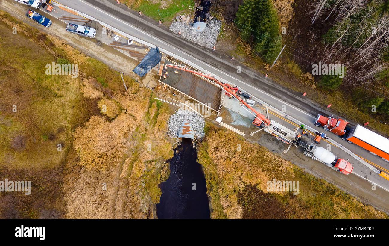 Calcestruzzo con pompa per calcestruzzo, per una lastra di emergenza sopra un canale rotto su una strada provinciale Foto Stock