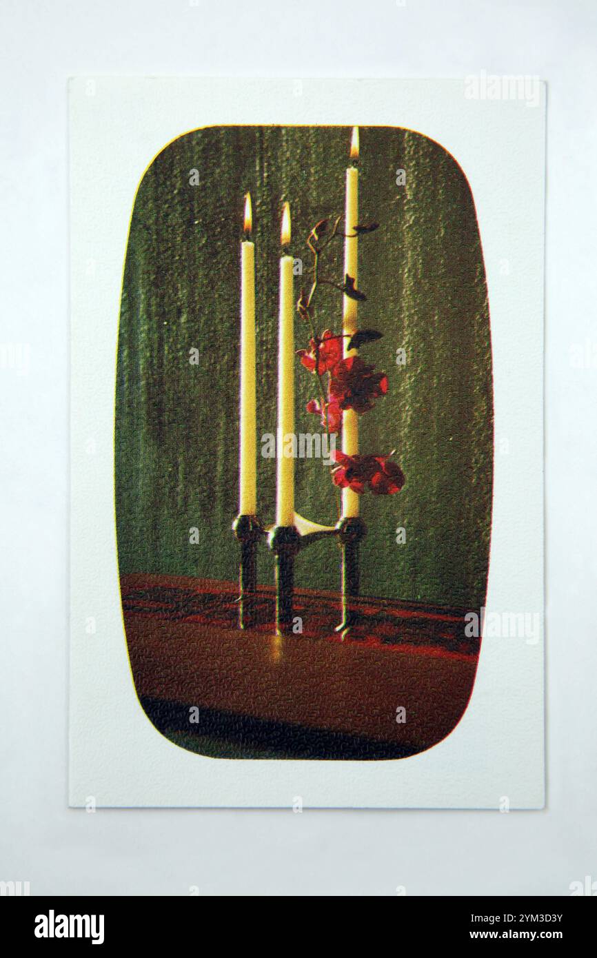 Biglietto d'auguri d'epoca raffigurante candele e fiori Foto Stock