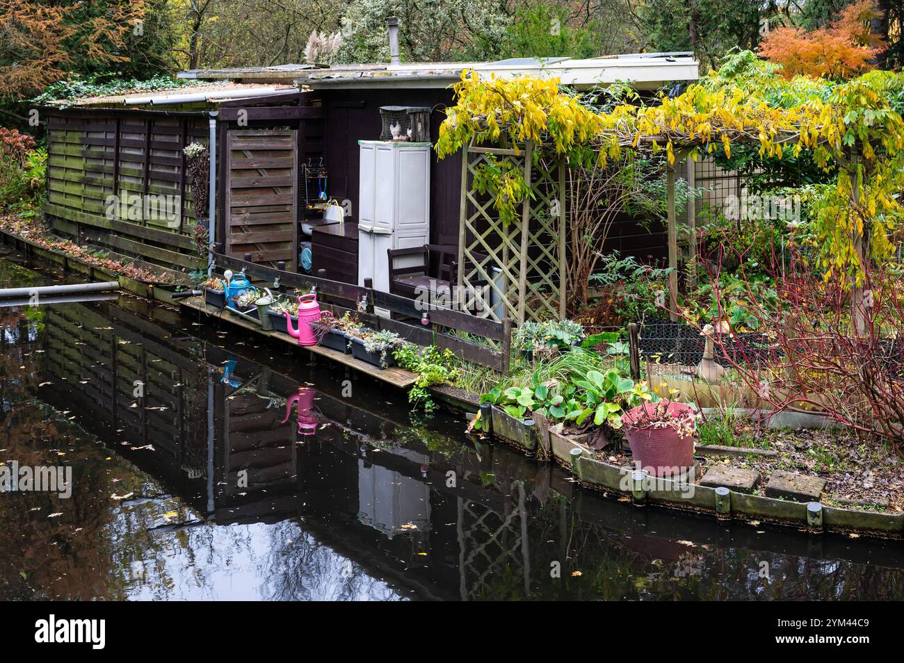 Capanna da giardino che si riflette nel canale presso i giardini pubblici di Amsterdam, Paesi Bassi, 14 novembre 2024 Foto Stock