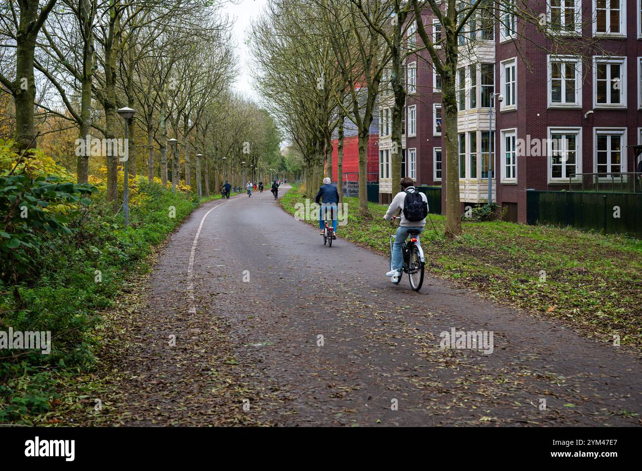 Ciclisti attraverso il giardino Tuinpark nut en Genoegen ad Amsterdam, Paesi Bassi, 14 novembre 2024 Foto Stock