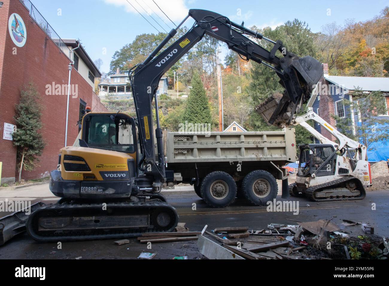I soldati dell'esercito americano con la 30th Armored Brigade Combat Team utilizzano un escavatore e una minipala per rimuovere i detriti nel centro di Marshall, North Carolina, 23 ottobre 2024. La Joint Task Force - North Carolina dispiega capacità militari a sostegno delle autorità statali al fine di proteggere la vita e le proprietà dei concittadini. (Foto della Guardia Nazionale dell'Esercito degli Stati Uniti a cura di staff Sgt. Denne Allen) Foto Stock