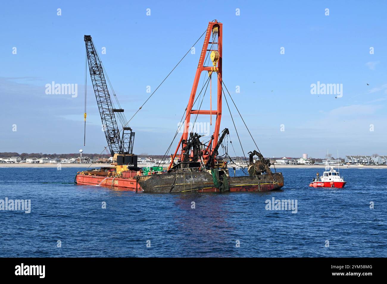 I Salvors lavorano per stabilizzare la nave da pesca Susan Rose di 77 piedi durante un'operazione di salvataggio al largo di Point Pleasant Beach, New Jersey, 19 novembre 2024. La Susan Rose veniva allevata dopo che era affondata mentre veniva rimorchiata fuori dalla spiaggia l'anno precedente. (Foto della Guardia Costiera degli Stati Uniti di Matthew West, sottufficiale di prima classe) Foto Stock