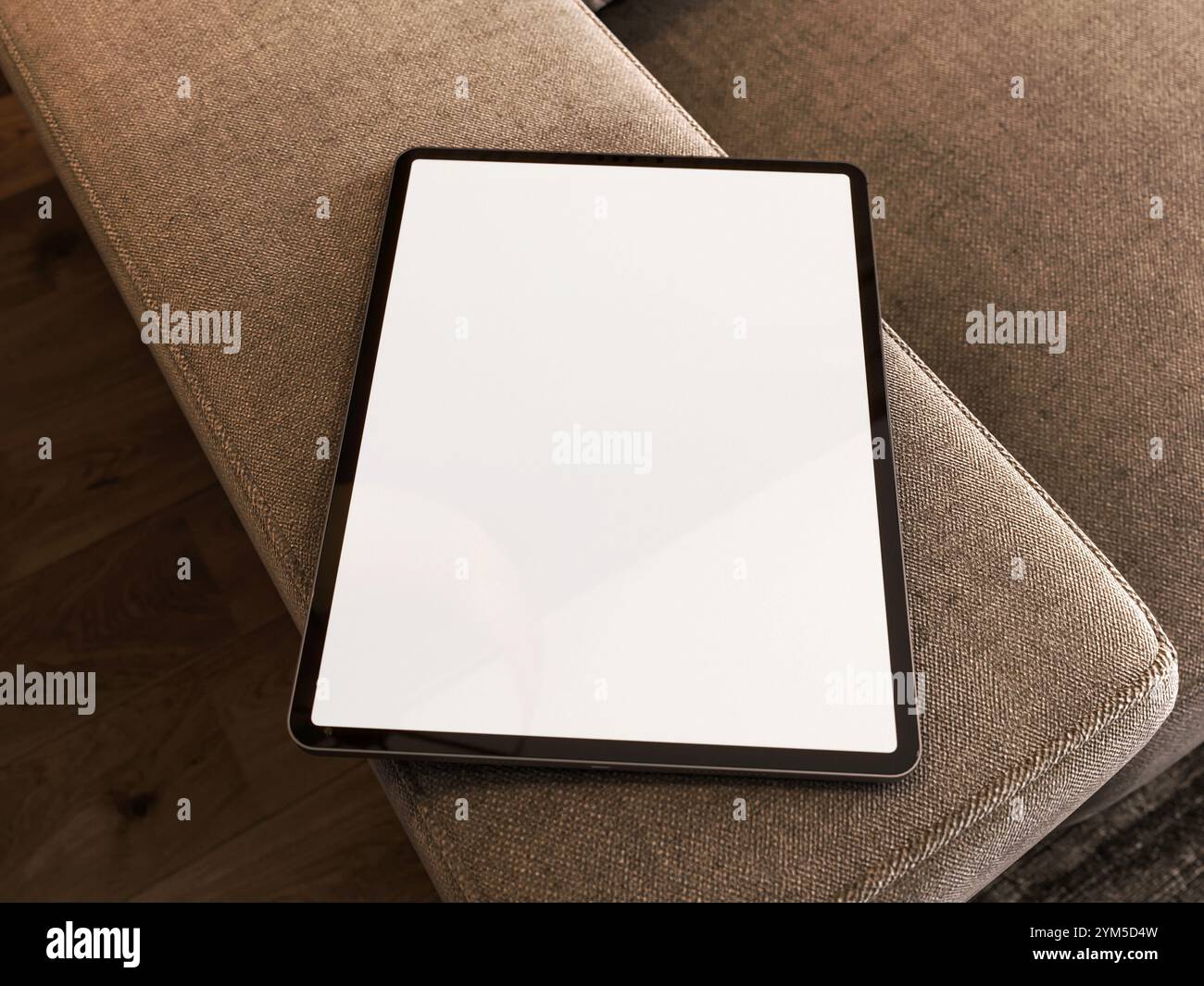 Un elegante iPad Pro su un comodo divano, con schermo vuoto e luce calda, perfetto per una presentazione. Rendering 3D. Foto Stock