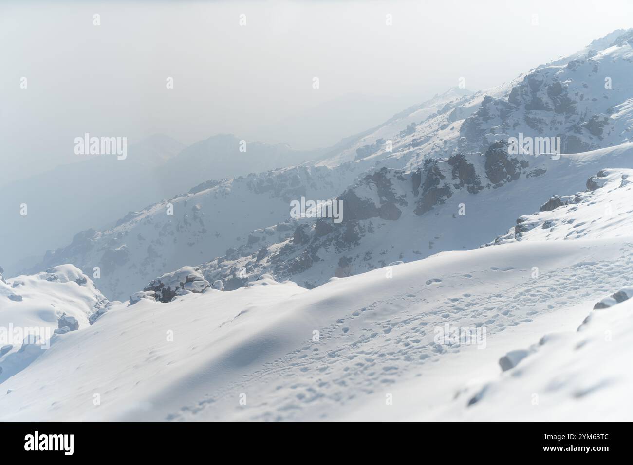 Catena montuosa innevata con Soft Fog e Rocky Peaks Foto Stock