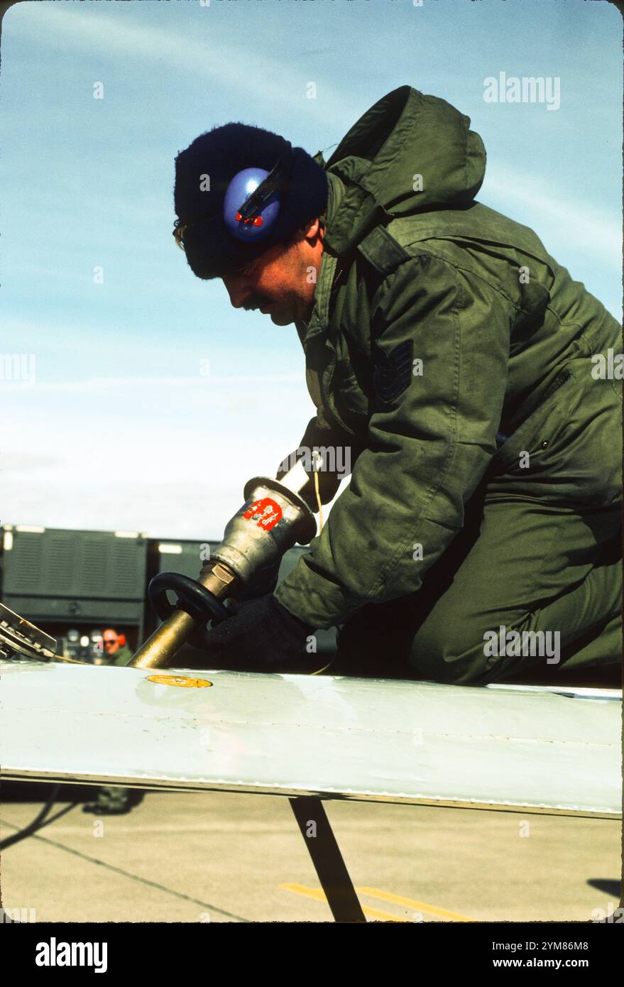 Crew Chief alimenta il T-33A dopo il volo. L'obsoleto sistema di alimentazione "over the Wing" ha sicuramente aggiunto il carico di lavoro dei T-33S. C'erano 7 carri armati che necessitavano di rifornimento, un serbatoio a punta e due serbatoi interni su ogni ala e il serbatoio della fusoliera. Ci voleva sicuramente pazienza. (Nome del capo equipaggio disponibile su richiesta) Foto Stock