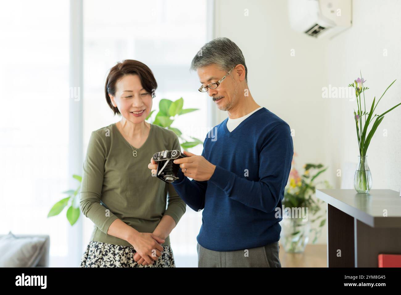 Una coppia anziana che tocca la fotocamera antica Foto Stock