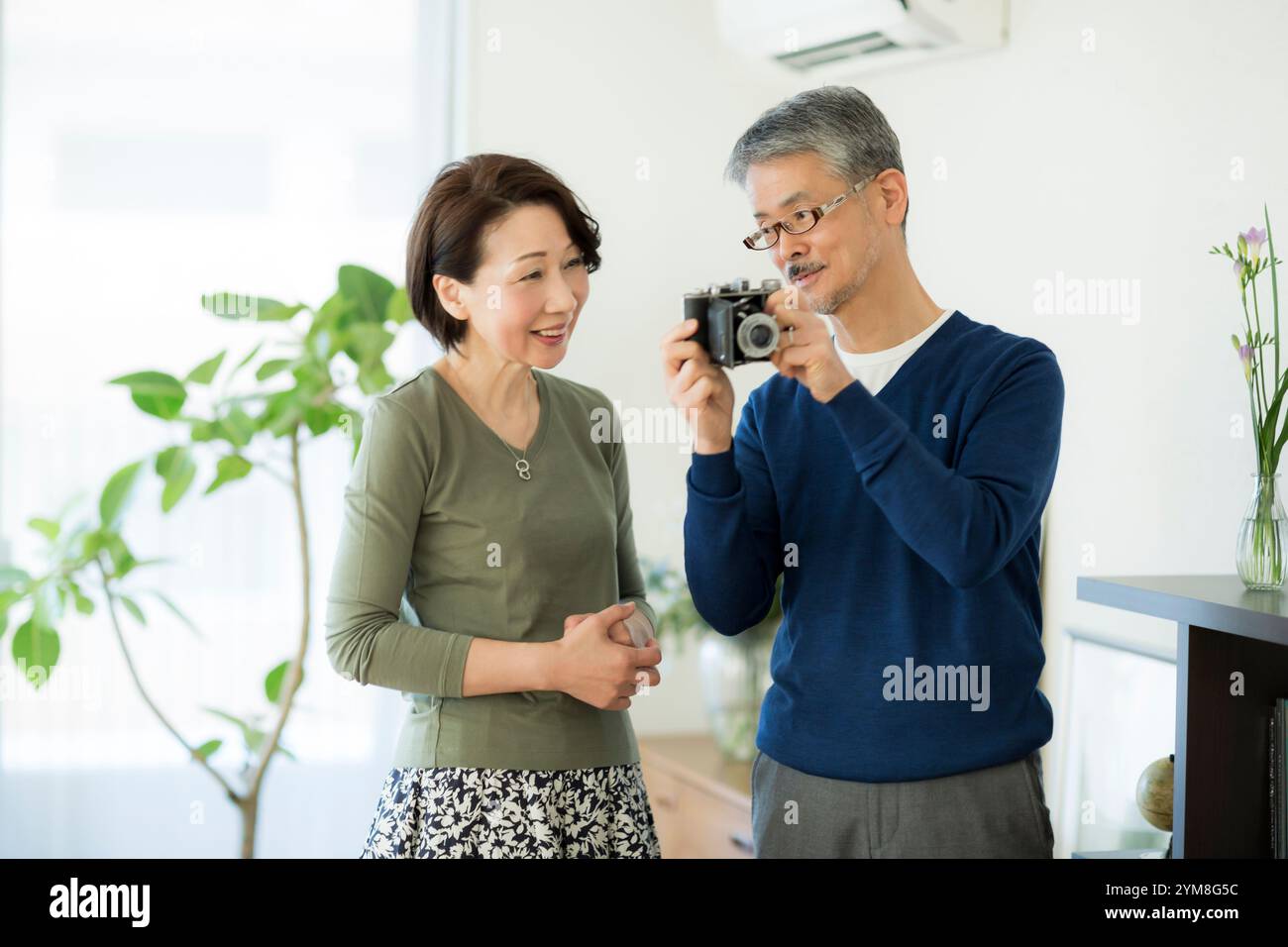 Una coppia anziana che tocca la fotocamera antica Foto Stock