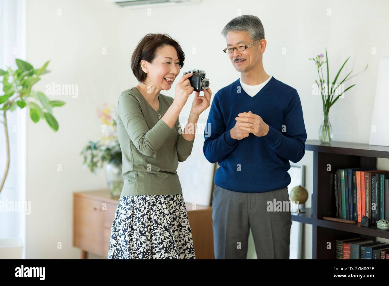Una coppia anziana che tocca la fotocamera antica Foto Stock