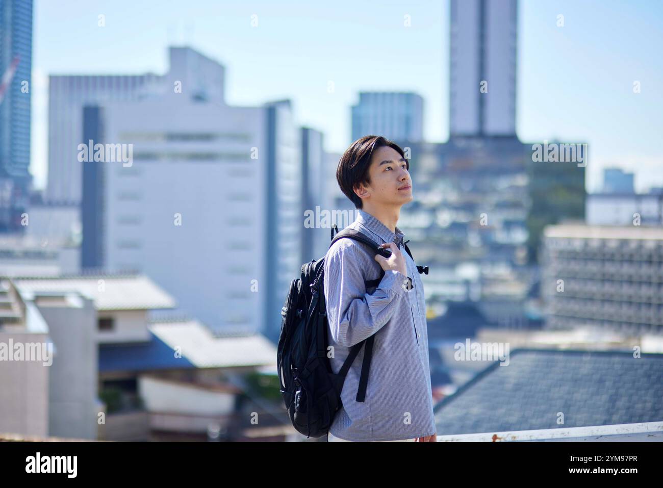 Studente universitario giapponese con zaino e paesaggio urbano Foto Stock