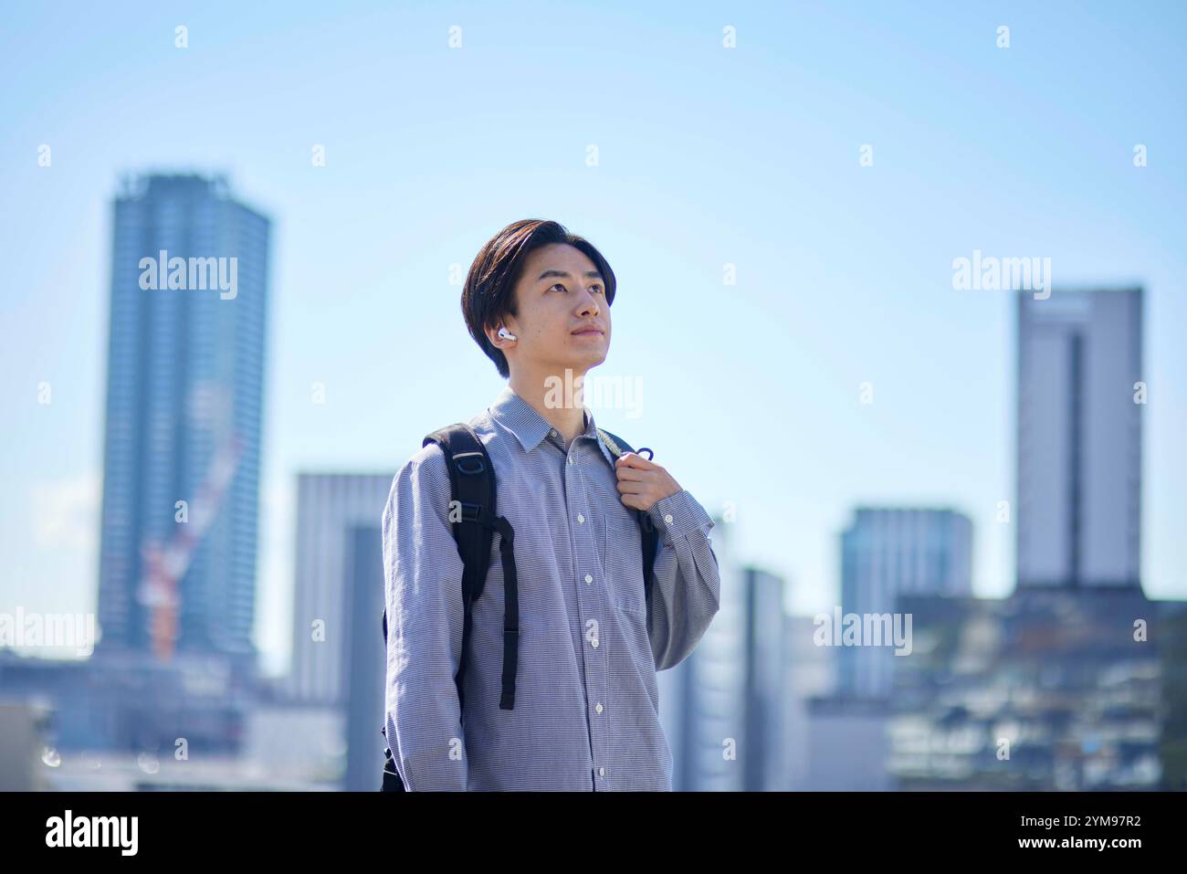 Studente universitario giapponese con zaino e paesaggio urbano Foto Stock