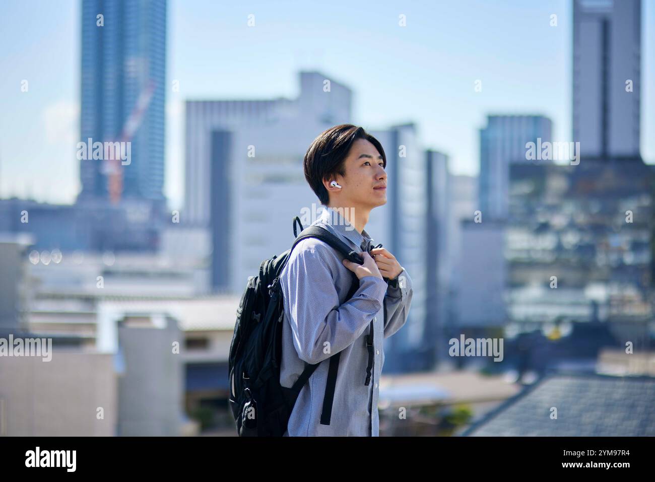 Studente universitario giapponese con zaino e paesaggio urbano Foto Stock