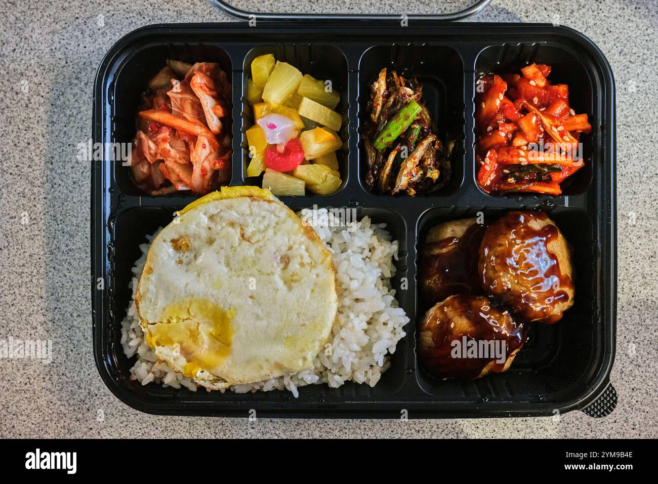 Un tradizionale dosirak coreano (pranzo al sacco) pieno di riso, contorni e sapori vivaci Foto Stock
