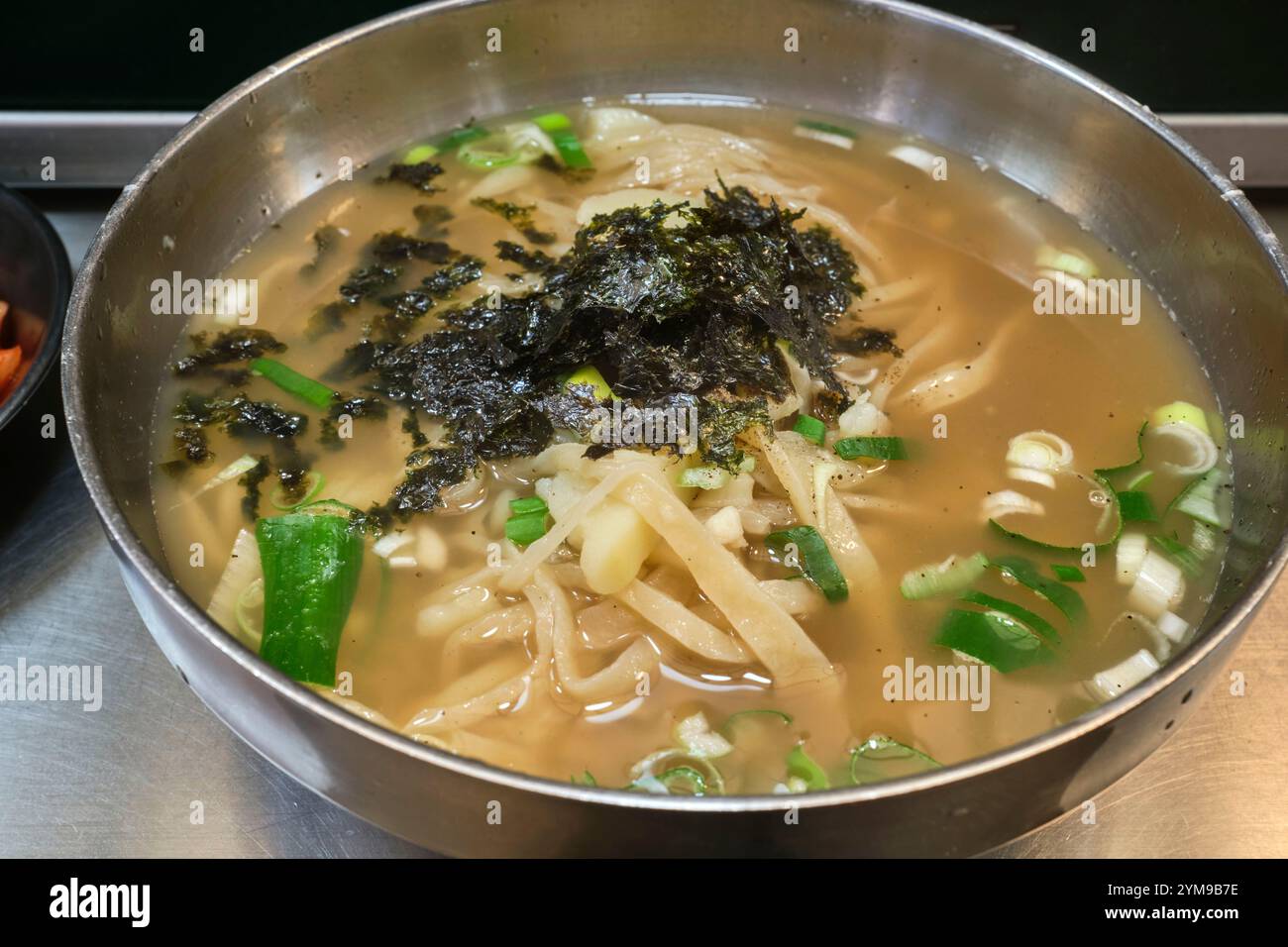Una ciotola di kalguksu, spaghetti coreani tagliati a coltello in un brodo salato Foto Stock