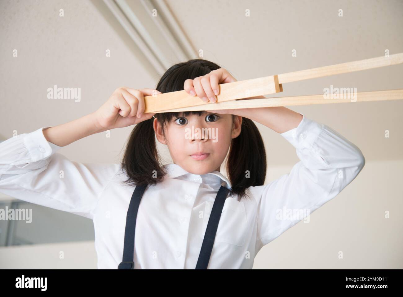 Ragazza della scuola elementare con una grande bussola Foto Stock