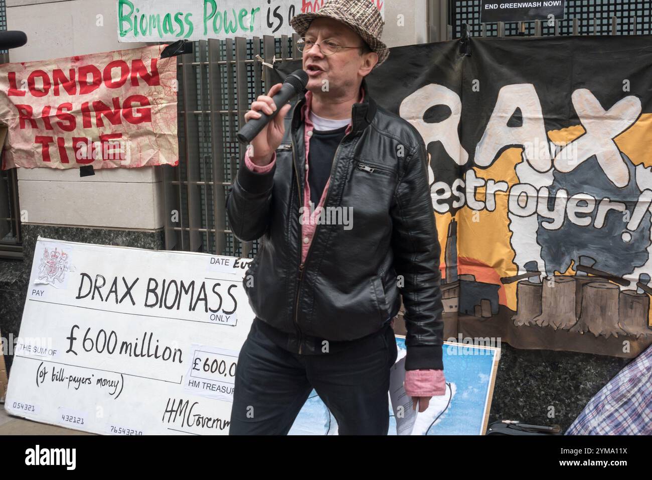 Londra, Regno Unito. 13 aprile 2017. Peter Dean, attivista di Biofuelwatch, parla in protesta fuori dagli uffici di Schroders, i principali azionisti di Drax, la 8217 più grande e inquinante centrale elettrica del Regno Unito, che brucia principalmente carbone dalla Colombia, dove l'estrazione a cielo aperto sta causando abusi dei diritti umani, terreni e inquinamento idrico e atmosferico, oltre a 13 milioni di tonnellate di pellet di legno all'anno, principalmente da taglio chiaro di foreste costiere paludose molto diverse negli Stati Uniti meridionali. Drax riceve un enorme sussidio di 1,5 milioni di sterline al giorno dalle nostre bollette elettriche destinate a finanziare energia rinnovabile pulita nonostante la sci Foto Stock