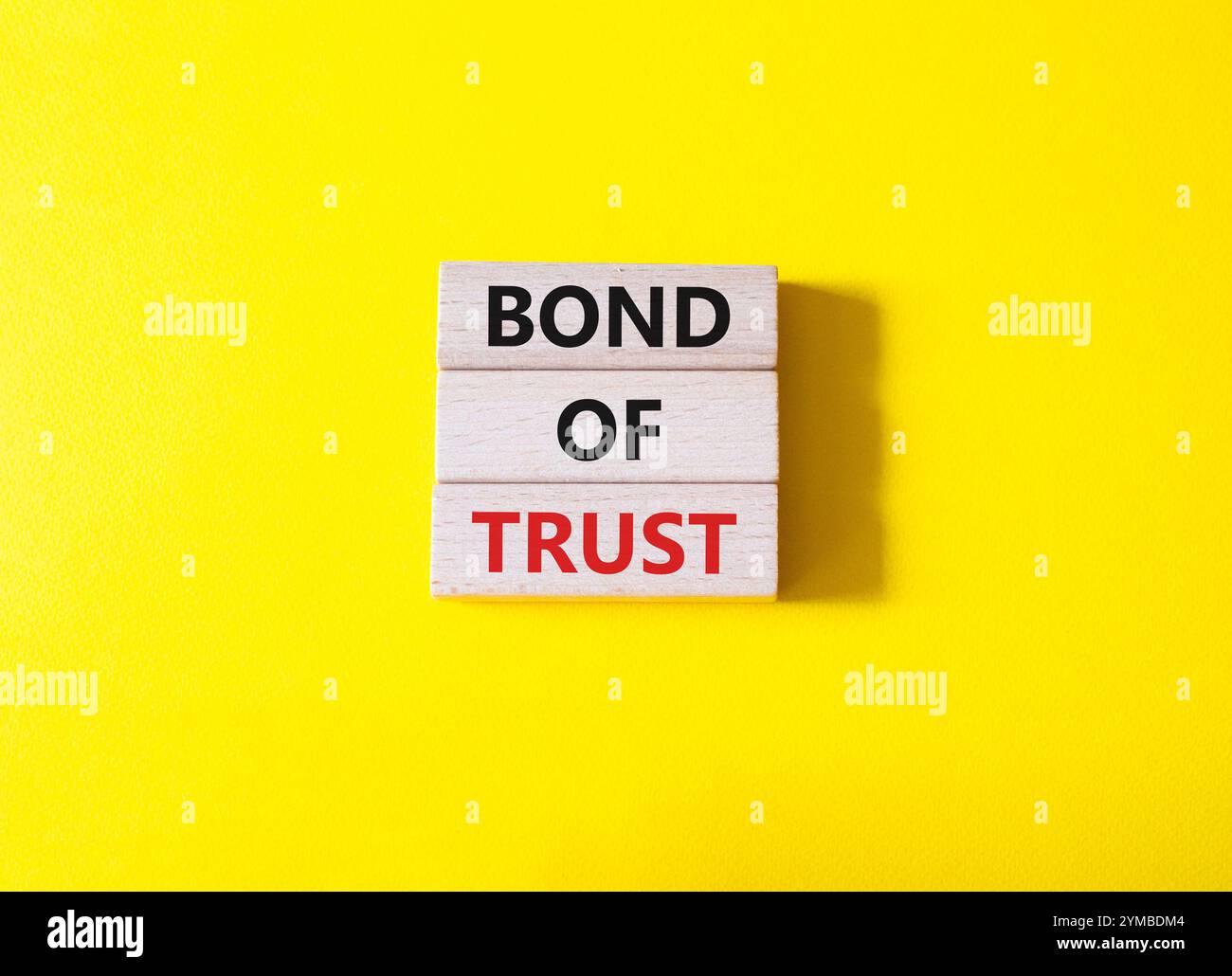 Simbolo del legame di fiducia. Blocchi di legno con parole Bond of Trust. Bellissimo sfondo giallo. Business e Bond of Trust. Copia spazio. Foto Stock