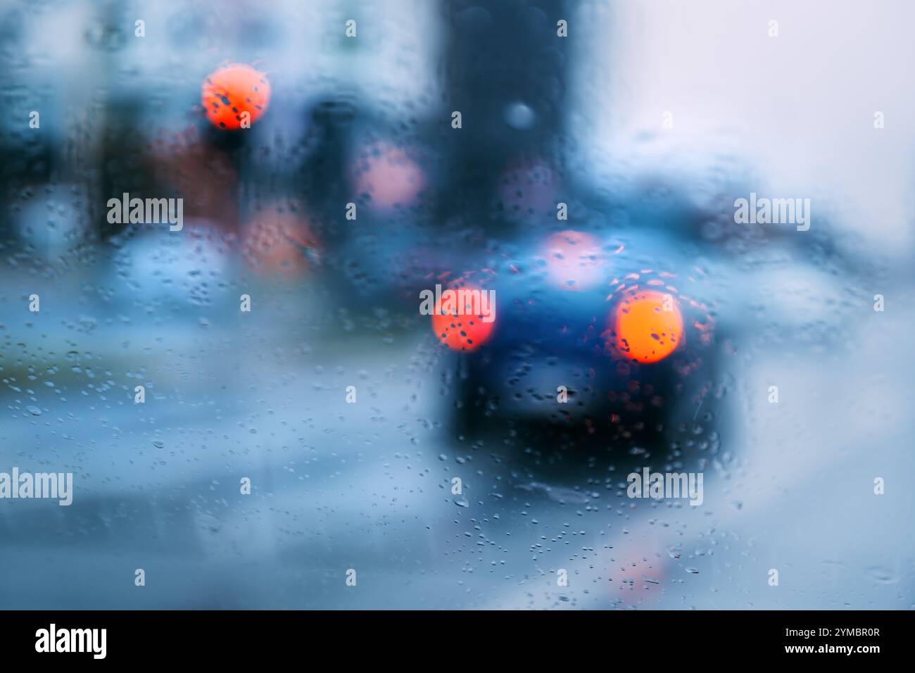 Auto e altri veicoli in pieno traffico cittadino in attesa di un semaforo verde in una giornata di pioggia, attenzione selettiva Foto Stock