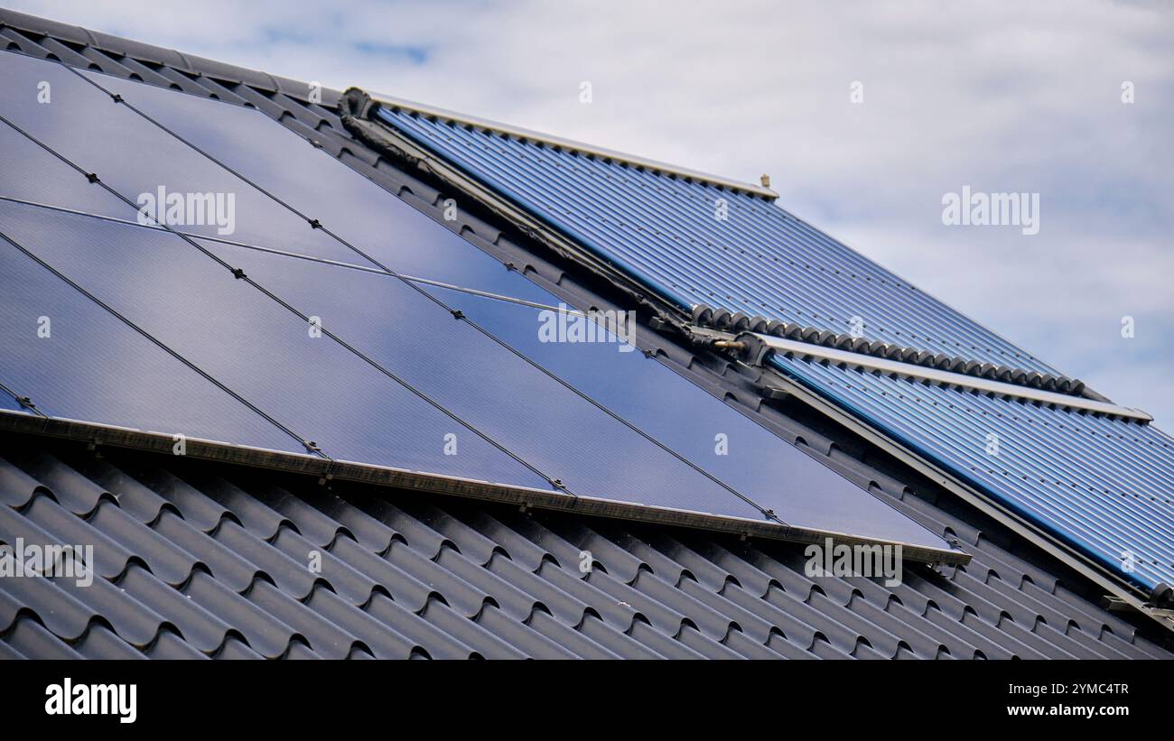 pannelli solari installati sul tetto di una casa residenziale, che mostrano l'integrazione dell'energia rinnovabile nella vita moderna. Tubi di calore e fotovoltaici Foto Stock