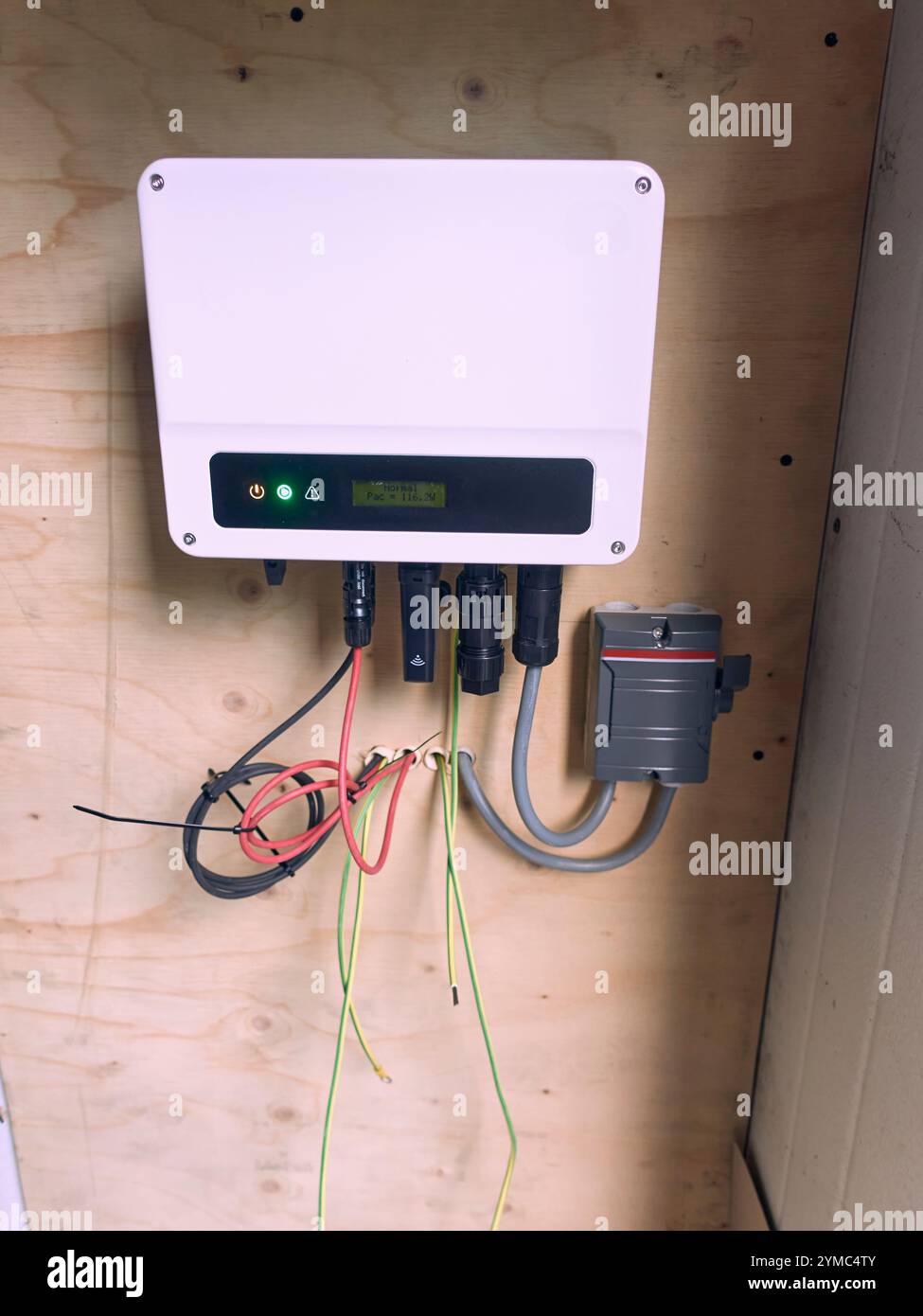Piccolo inverter solare residenziale installato in una casa olandese su un pannello di legno, completo di interruttore di manutenzione e messa a terra. Foto Stock