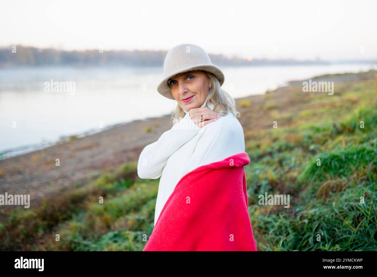 Ritratto di donna in cappello bianco sulla riva del lago Foto Stock