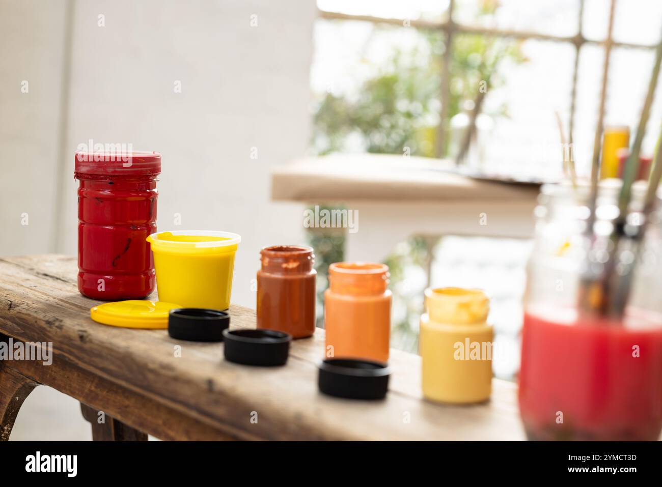 Vasi colorati su un tavolo rustico, pronti per progetti artistici creativi, a casa Foto Stock