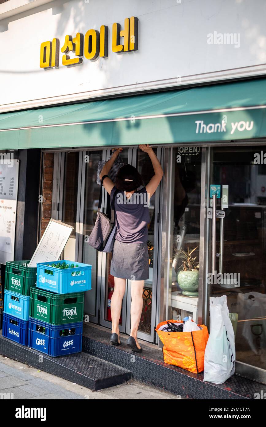 Woman Closing Store nel quartiere dello shopping di Myeongdong nel centro di Seoul, capitale della Corea del Sud, il 24 luglio 2023 Foto Stock