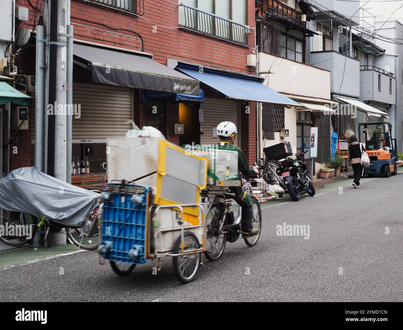 TOKYO, GIAPPONE - 14 novembre 2024: Un carrello della compagnia di consegna Yamato (Kuroneko) e una bicicletta elettrica in una strada nella zona di Nezu a Tokyo. Foto Stock
