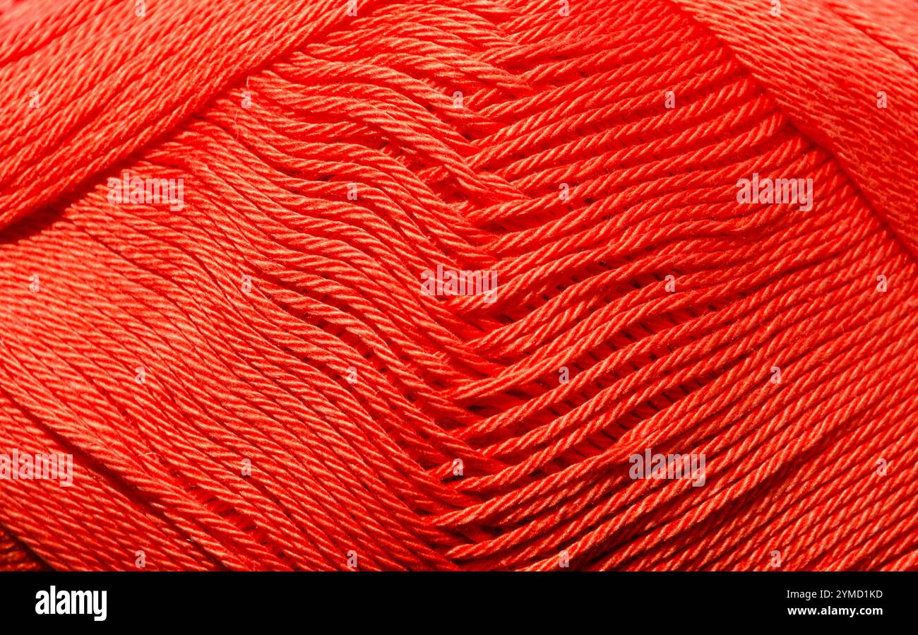 Consistenza del filato di cotone mercerizzato di colore rosso. La superficie del filo trattata con soda caustica è più liscia e lucida, un po' come la seta. Foto Stock