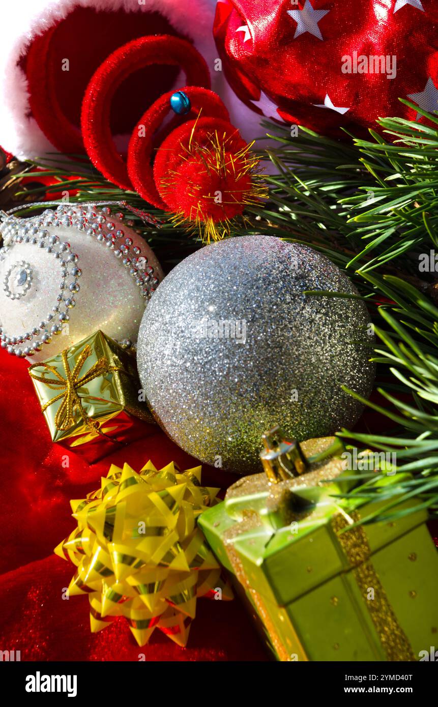 Palla d'argento, archi e stelle, su sfondo rosso. Decorazioni per il nuovo anno e il Natale. Un posto per le congratulazioni. Foto Stock