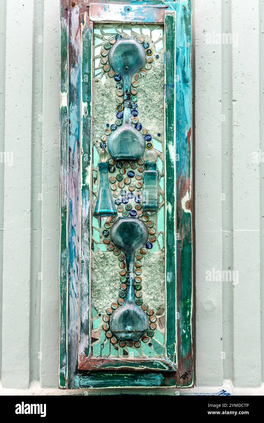Su un muro accanto al viadotto di Aruba a Willemstad, i collage di oggetti da collezione di Curacao, tutti firmati TOPO 13, appendono poco appariscenti sulle cornici delle finestre scartate. Willemstad, Curacao, Curacao, Kòrsou Foto Stock